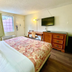 Red Carpet Inn - New Brunswick guest room with queen bed, desk, wall-mounted TV and window