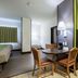Studio 6 Bay City, TX room with table, chairs, bed, kitchenette and green accent wall