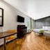 Studio 6 Portland OR guest room with two beds, wood floors, desk, TV, and window light