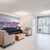 Clarion Pointe Winston-Salem Downtown lobby with seating, city mural, and sliding glass doors to outside