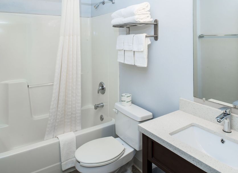 Luxbury Inn & Suites Maryville bathroom with tub-shower combo, toilet, sink, and towel rack