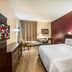 Red Roof Plus Long Island - Garden City room in Westbury with king bed, TV, desk and window seating