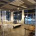 Pohang Youngildae Guesthouse lounge with white tables, chairs, and large street-facing windows in Pohang