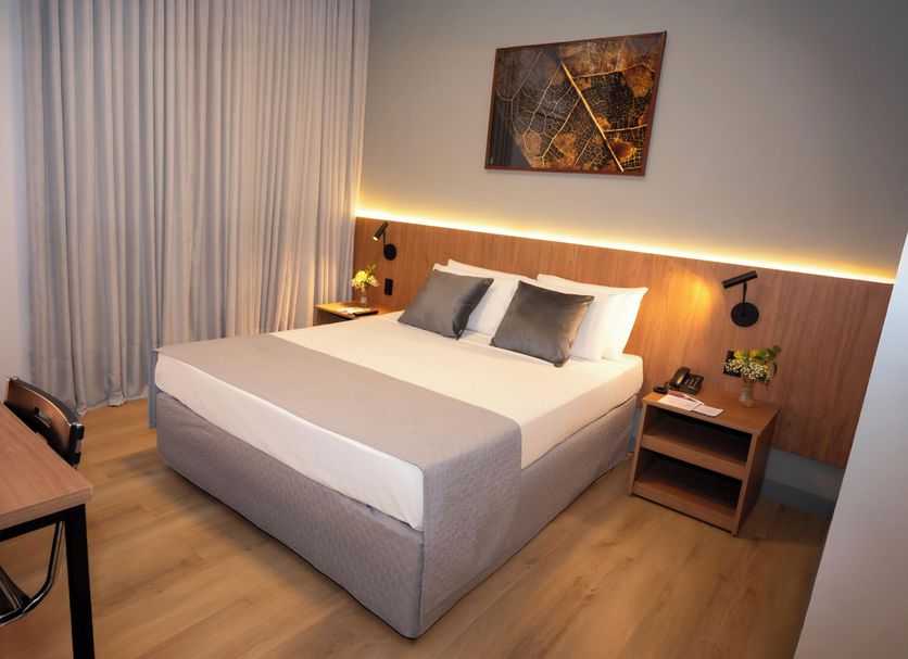Delcas Hotel, Cuiabá: guest room with double bed, wood headboard, bedside tables and curtains