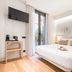 Casa Bella Gracia by Aspasios Barcelona room with double bed, wall-mounted TV and balcony door