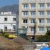 Hotel Mediterráneo by Croma in Estepona, beige hotel building behind beach umbrellas and nearby mountains