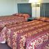 Scottish Inns Mcminnville room with two double beds and a bedside lamp in McMinnville
