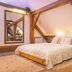 Wellness Pension Ametyst in Český Krumlov bedroom with exposed wooden beams and a large bed