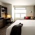 Hyatt House Augusta Downtown guest room with king bed, work desk, and sofa seating