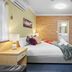 Park Beach Resort Motel room in Coffs Harbour with bed, kitchenette and brick accent wall