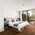 The Kooralbyn Valley bedroom with king bed and sliding glass doors to a patio and garden view