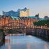 Ibis Hamburg Alsterring in Hamburg with canal, bridge, and waterfront city buildings at dusk