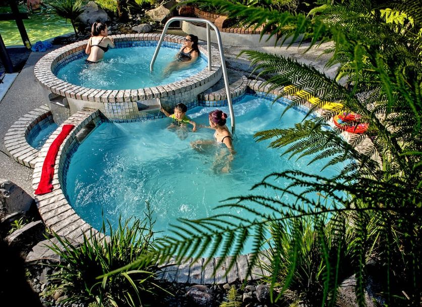 Taupo Debretts Spa Resort in Taupo with outdoor pools and guests soaking in thermal water