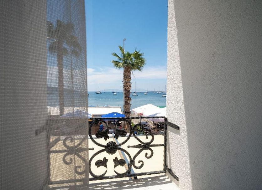 Artemis Hotel, Bodrum: sea view from balcony with palm tree, wrought-iron railing and beach umbrellas