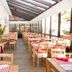 Hotel Bristol Verbier in Bagnes, glass-roofed dining room with wooden tables and red checkered tablecloths