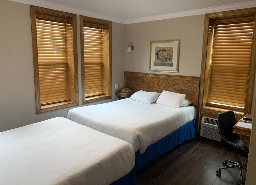 District Hotel Washington, D.C. room with two beds, wood blinds, and a desk chair