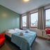 Loft - Hi Eco Hostel Reykjavik guest room with bed, red chairs and city views