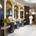 Onyx Rotana Manama lobby with marble flooring, gold mirrors, floral arrangement and sculpture