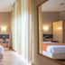 Vila Nova Guesthouse in Lisbon room with bed, bedside lamps, wardrobe and floor-to-ceiling curtains