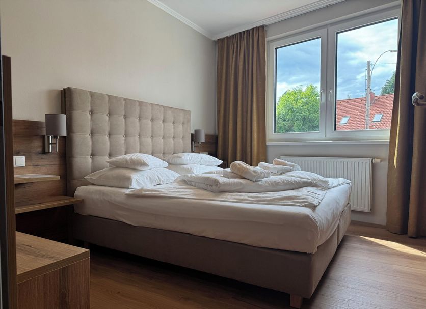 Der Marienhof Hotel Garni in Graz guest room with a double bed and large window view