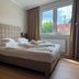 Der Marienhof Hotel Garni in Graz guest room with a double bed and large window view
