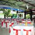 Grand Crown Hotel in Anuradhapura outdoor dining area with tables and chairs dressed in red and white