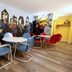 Medicine Hat Suites meeting area with superhero mural, round tables, and colorful chairs in Medicine Hat