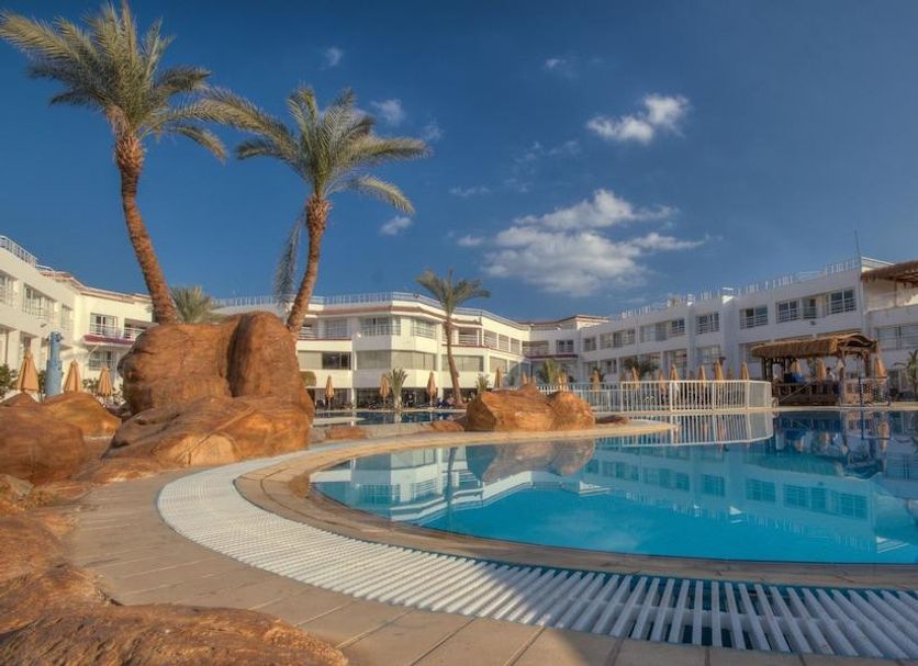 Sharming Inn Hotel, Sharm el-Sheikh: outdoor pool with palm trees and white resort buildings
