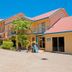 Beach Court Holiday Villas in Airlie Beach with palm-lined villas and balconies under a bright blue sky