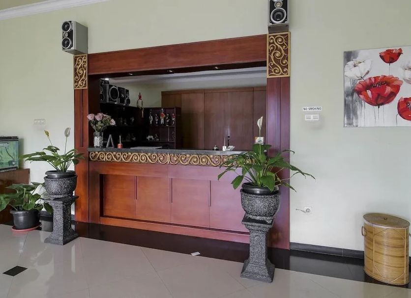 RedDoorz @ Seturan Raya 2 in Depok lobby bar with wooden counter and potted plants