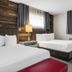 Lake Placid Inn: Residences guest room with two beds, wood accent wall and dresser in Lake Placid