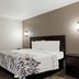 Red Roof Inn Hartford - New Britain guest room with queen bed, wall sconces, and window with curtains.