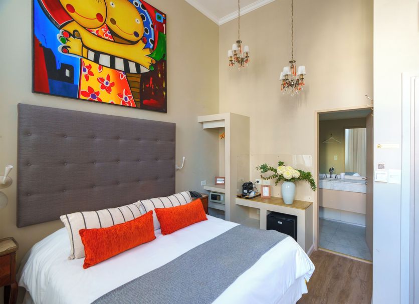 Rendez Vous Hotel Buenos Aires guest room with colorful wall art, king bed, and vanity area