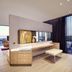 Hilton Tallinn Park in Tallinn: modern guest room with desk, bench seating, and city views through floor-to-ceiling windows