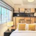 Casa Panuco in Mexico City guest room with bed, wood shelving, and a window overlooking trees