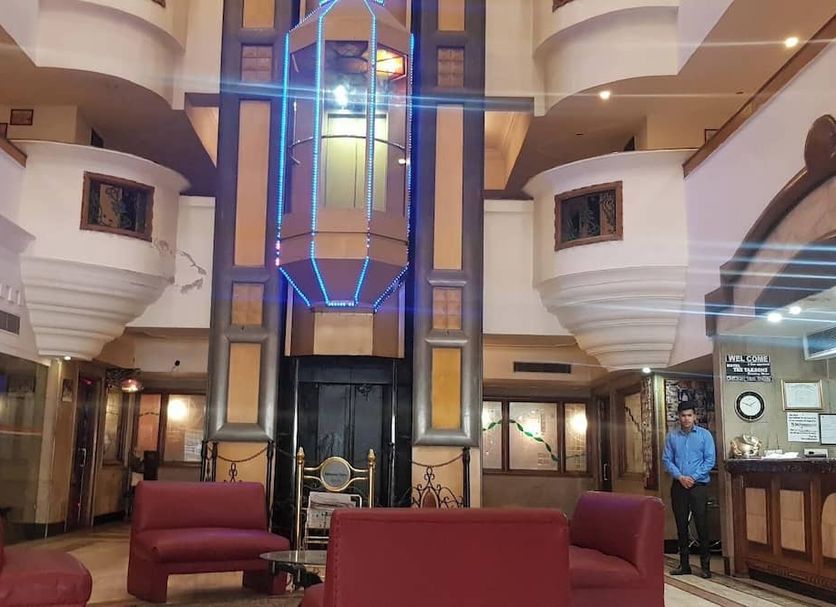 Hotel The Taksonz lobby in Ludhiana with modern seating and a glass elevator shaft