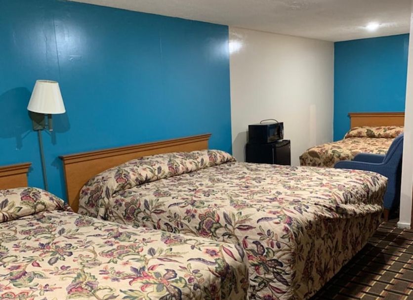 Blue Falls Motel in Tonawanda, guest room with three floral beds and blue accent walls