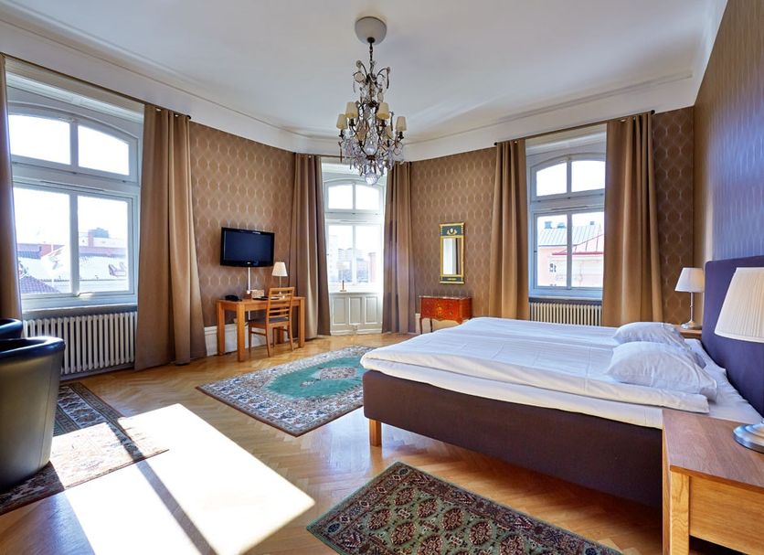First Hotel City Eskilstuna guest room with bed, chandelier, windows and TV in Eskilstuna