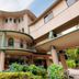 Hakonenomori Okada in Hakone with curved balconies, large windows, and surrounding garden