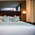 Atrium Hotel Heathrow, Hounslow guest room with king bed, mirrored wall and bedside lamps