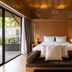 ananea Beyond Khaolak bedroom in Takua Pa with king bed, lounge bench, and sliding doors to a patio