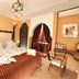 Riad Belle Epoque Marrakech guest room with ornate bed, arched alcove, and desk