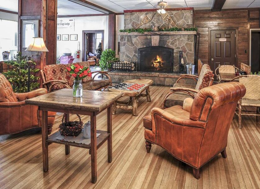 The Historic Crags Lodge in Estes Park lounge with stone fireplace, leather chairs and mountain lodge decor