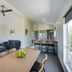 The Retreat at West Beach Parks living and dining area with sofa, table, bar stools and windows