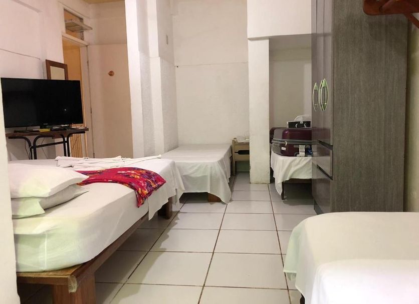 Pousada Caravelas, Guarapari: simple hotel room with three single beds, TV, and wardrobe