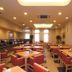 Hotel Route-Inn Utsunomiya Miyukicho restaurant with tables and red chairs in a bright dining room