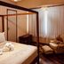 Boutique Hotel Casa Teatro room in Manaus with four-poster bed, armchair, and sheer curtains