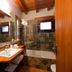Hotel-Apartamento Rural Atxurra bathroom in Bermeo with wood vanity, mirror, tiled tub and small window.