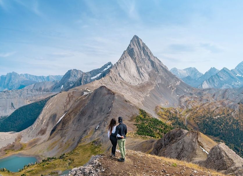 Mount Engadine Lodge in Canmore with hikers overlooking a mountain ridge and alpine lake