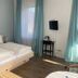 Hotel Markgräfler Hof in Badenweiler guest room with twin bed, wall-mounted TV, and sheer curtains